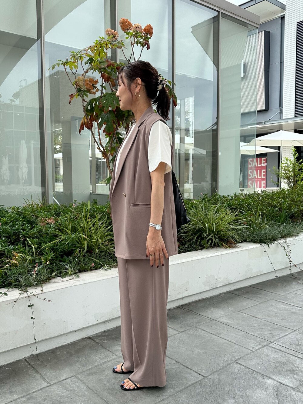 イエロー系のテーラードジャケット、イエロー系のその他パンツ、ホワイト系のTシャツ/カットソーを着用したレディースの夏コーディネートの3枚目の写真