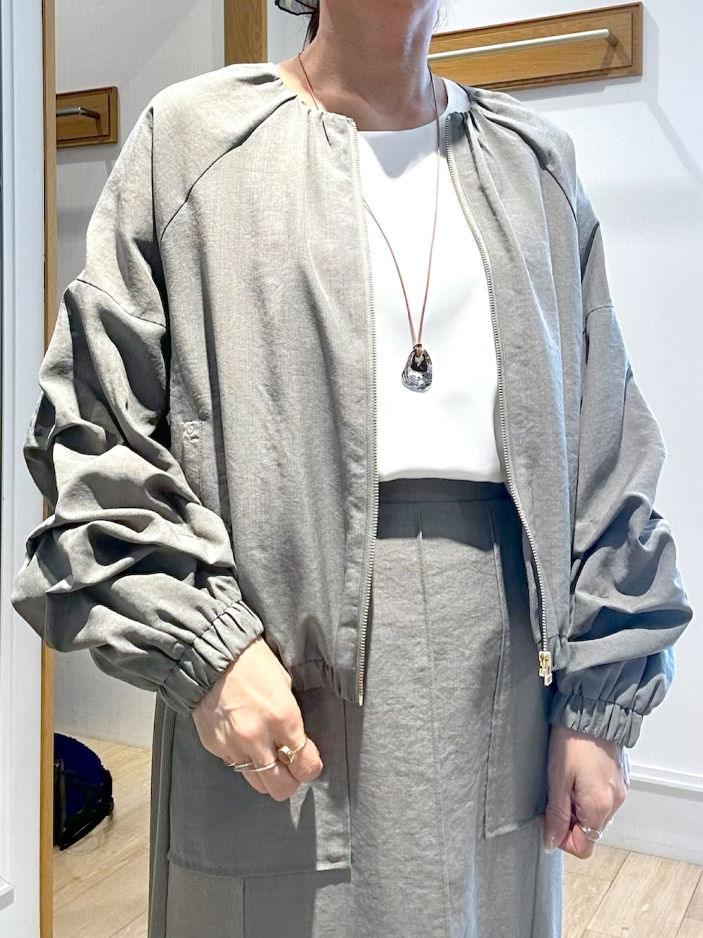 ホワイト系のTシャツ/カットソー、グリーン系のスカート、ブラック系のブルゾンを着用したレディースの春コーディネートの5枚目の写真