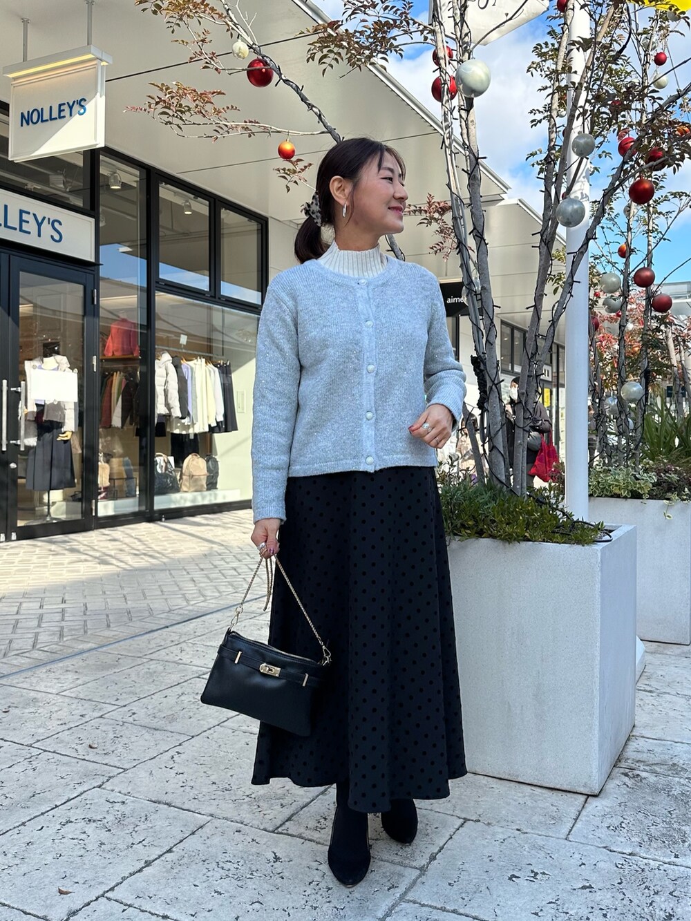 グレー系のニット/セーター、ブラック系のショルダーバッグを着用したレディースの冬コーディネートの5枚目の写真