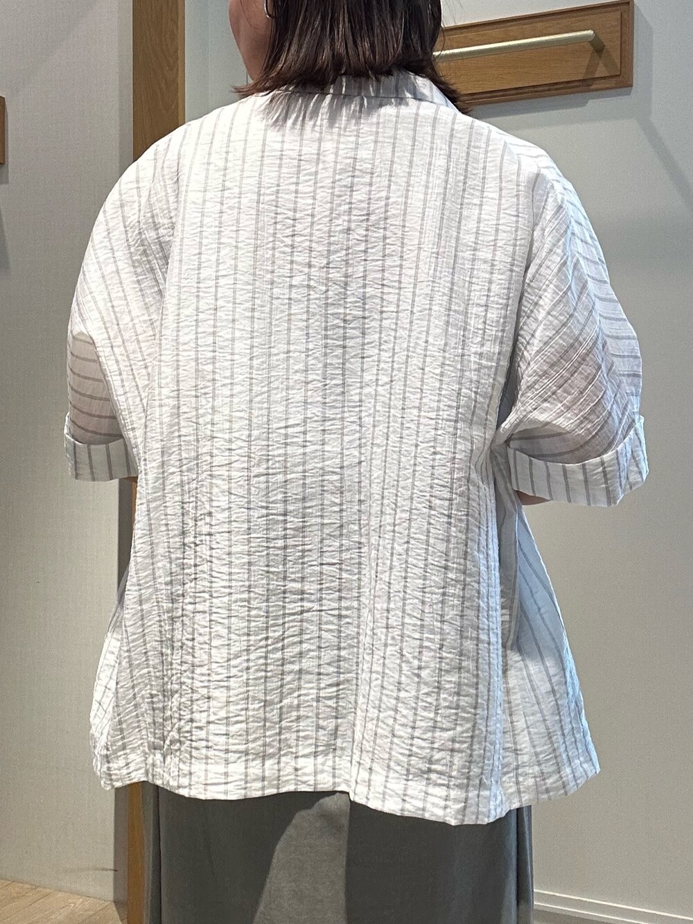 グレー系のテーラードジャケット、ホワイト系のTシャツ/カットソー、グリーン系のスカートを着用したレディースの夏コーディネートの7枚目の写真