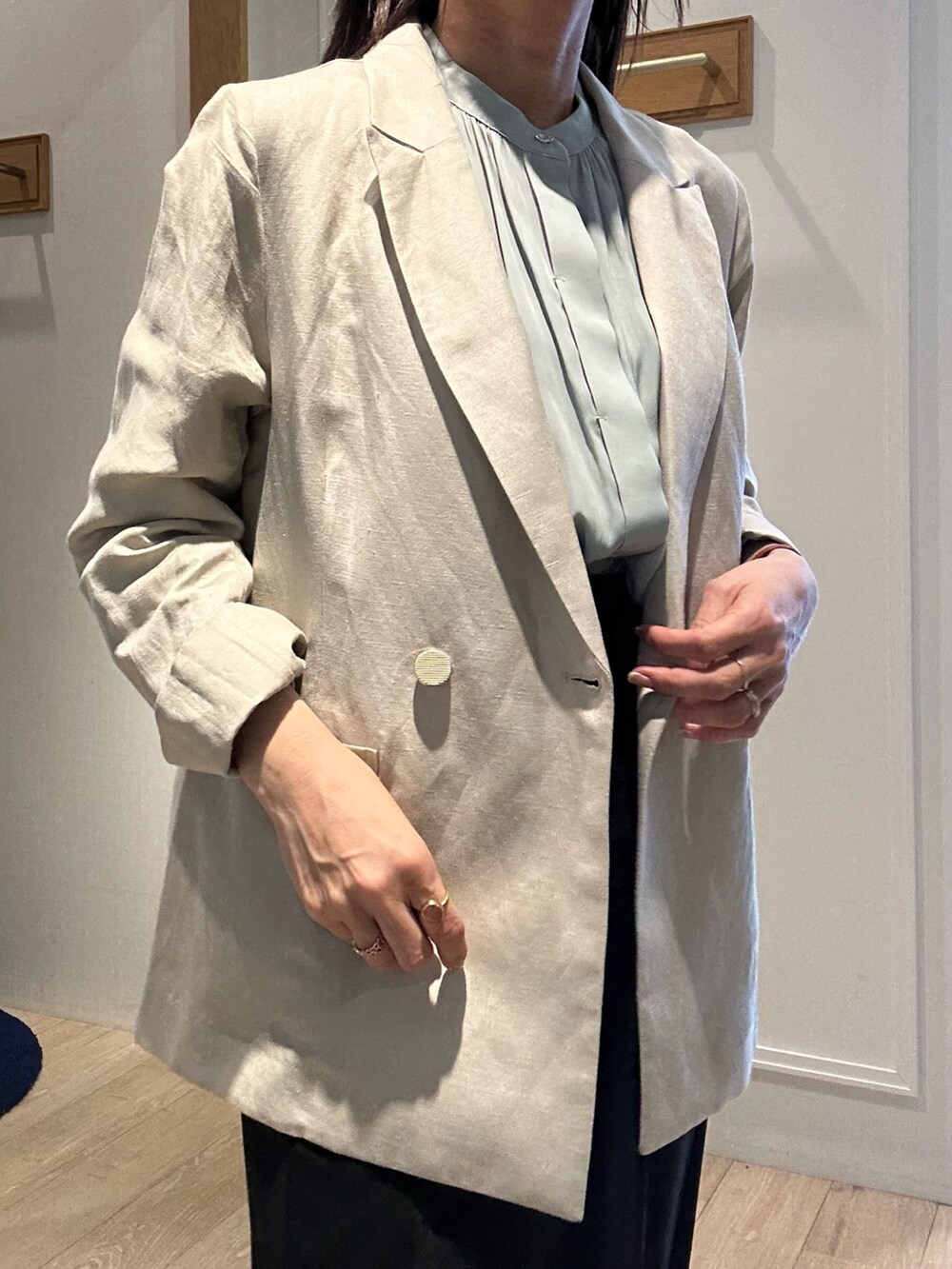 ベージュ系のテーラードジャケット、グリーン系のシャツ/ブラウス、ブラック系のスカートを着用したレディースの春コーディネートの5枚目の写真