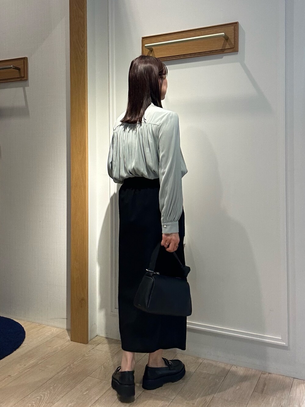 グリーン系のシャツ/ブラウス、ブラック系のスカート、ブラック系のショルダーバッグを着用したレディースの春コーディネートの4枚目の写真
