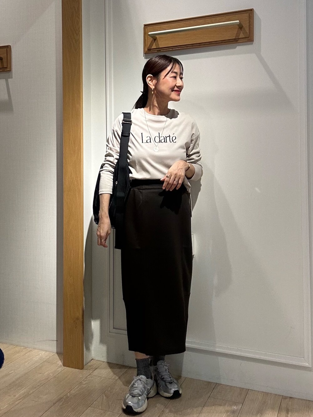 ブラウン系のパーカー、ブラウン系のスカート、ブラック系のショルダーバッグを着用したレディースの秋コーディネートの10枚目の写真