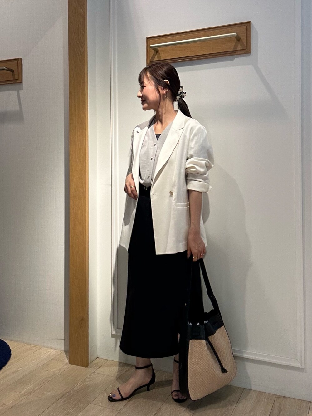 ホワイト系のテーラードジャケット、ベージュ系のシャツ/ブラウス、ブラック系のスカートを着用したレディースの夏コーディネートの2枚目の写真