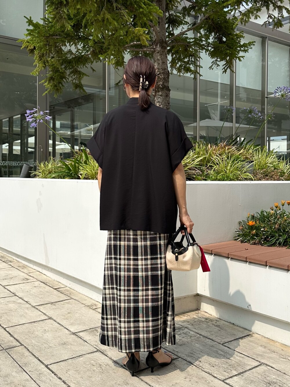 ブラック系のテーラードジャケット、ホワイト系のTシャツ/カットソー、ブラック系のバックパック/リュックを着用したレディースの夏コーディネートの3枚目の写真