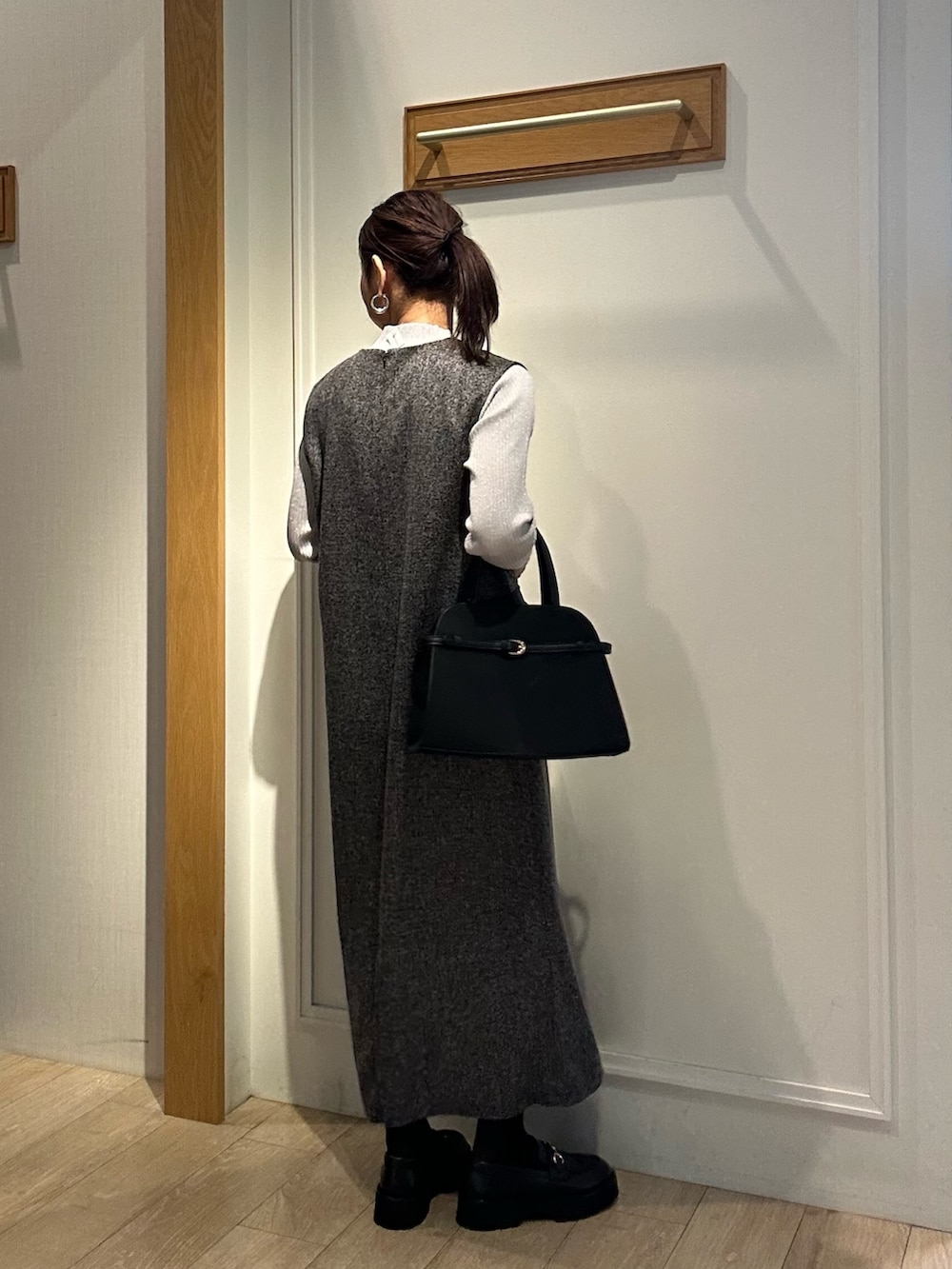 グレー系のワンピース、ブラック系のトートバッグを着用したレディースの秋コーディネートの2枚目の写真