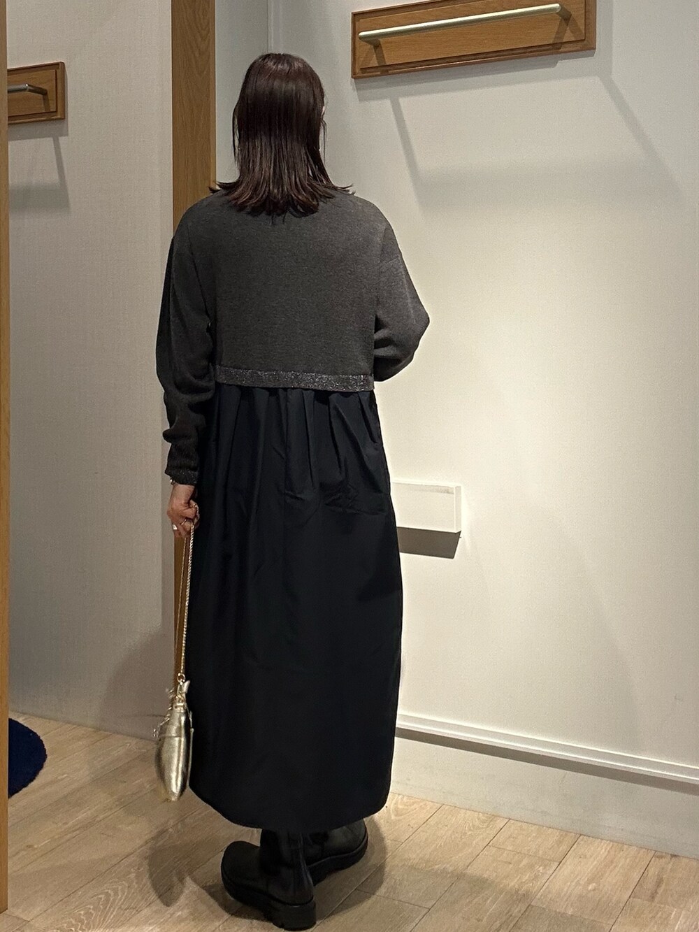 グレー系のワンピース、ゴールド系のショルダーバッグを着用したレディースの冬コーディネートの3枚目の写真