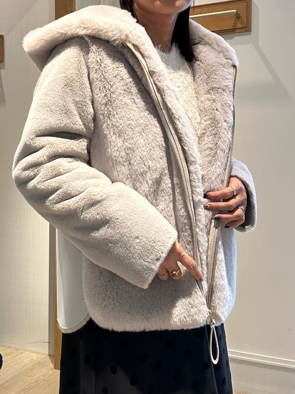 ベージュ系のムートンコート、ブルー系のニット/セーター、ホワイト系のニット/セーターを着用したレディースの冬コーディネートの6枚目の写真