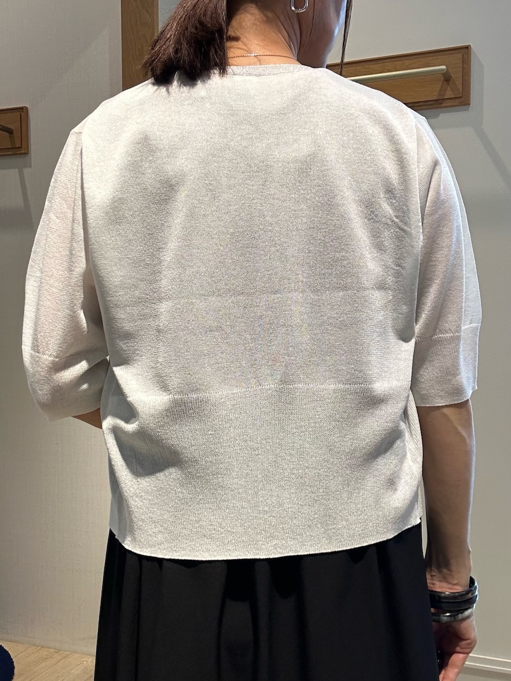 ホワイト系のニット/セーター、ブラック系のワンピース、ブラック系のサンダルを着用したレディースの夏コーディネートの8枚目の写真