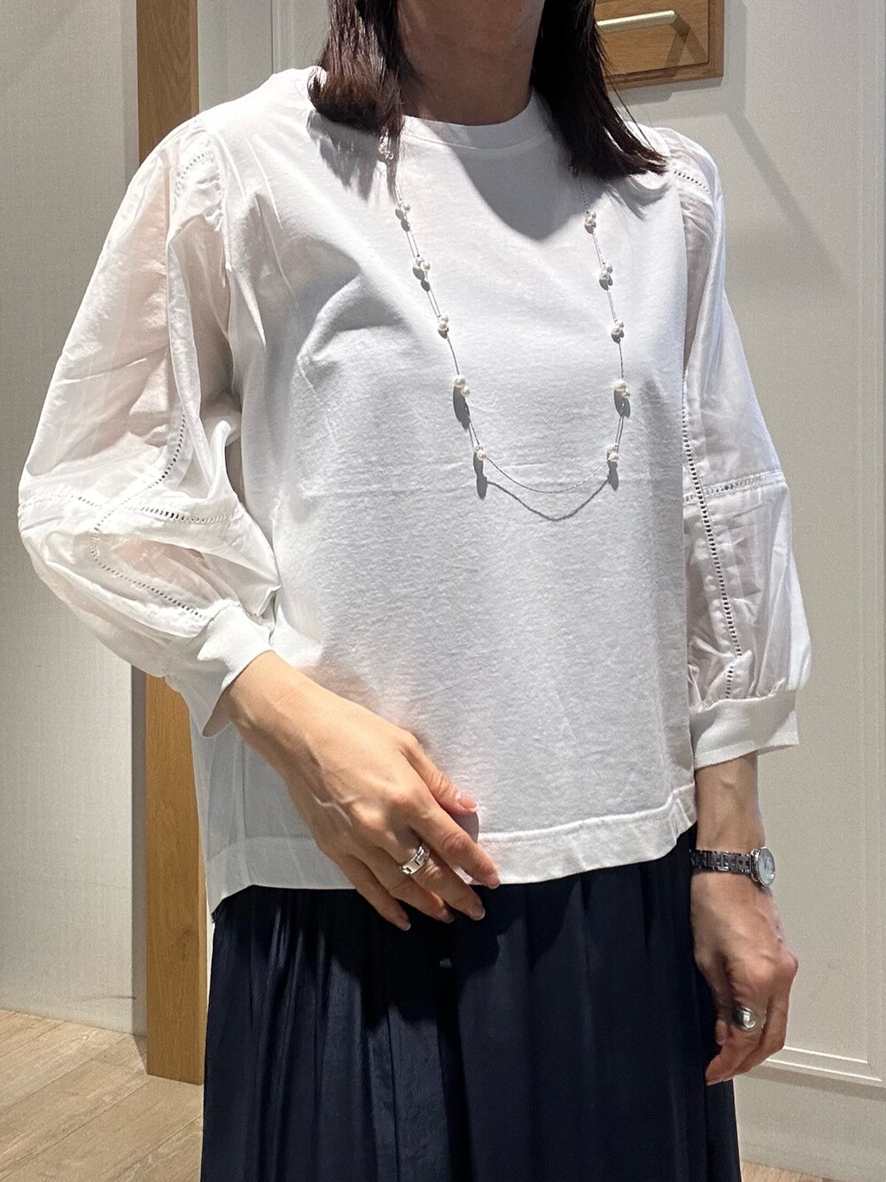 ホワイト系のTシャツ/カットソー、ベージュ系のスカートを着用したレディースの春コーディネートの3枚目の写真