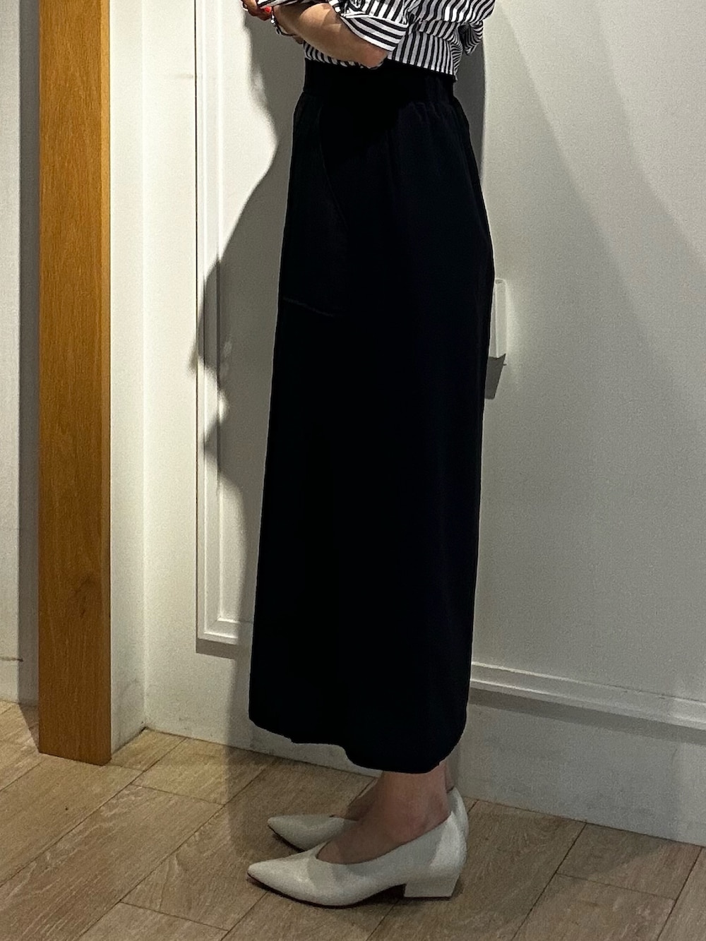 ブラック系のスカート、グレー系のシャツ/ブラウスを着用したレディースの春コーディネートの9枚目の写真