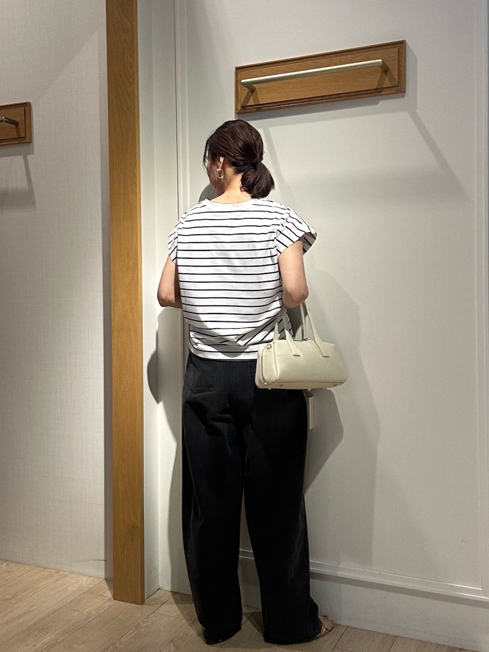 ホワイト系のTシャツ/カットソー、ブラック系のサンダル、ホワイト系のボストンバッグを着用したレディースの夏コーディネートの4枚目の写真