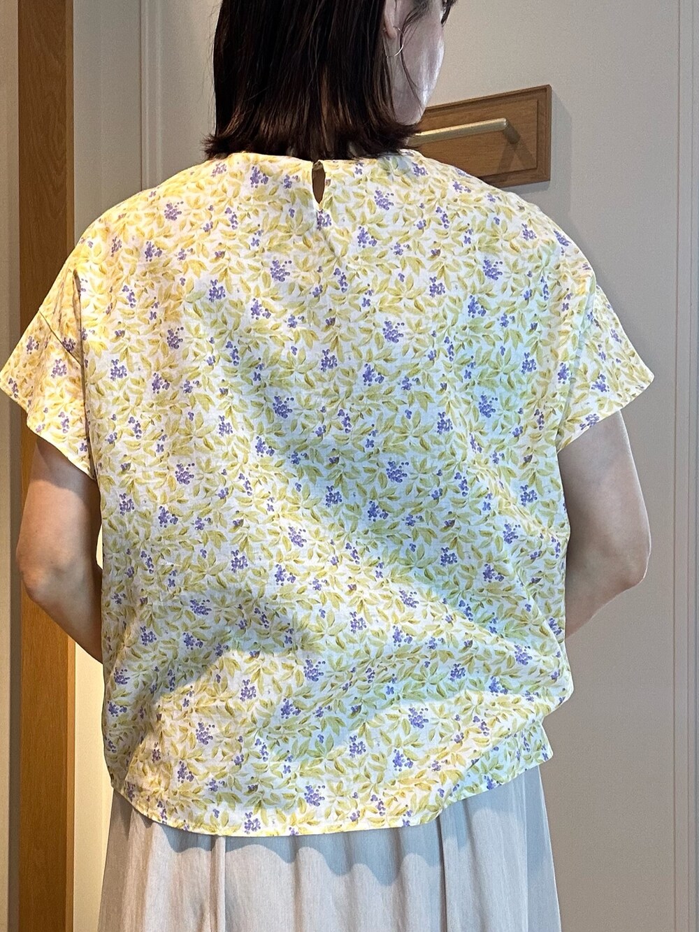 ホワイト系のスカート、イエロー系のシャツ/ブラウス、ゴールド系のネックレスを着用したレディースの春コーディネートの6枚目の写真