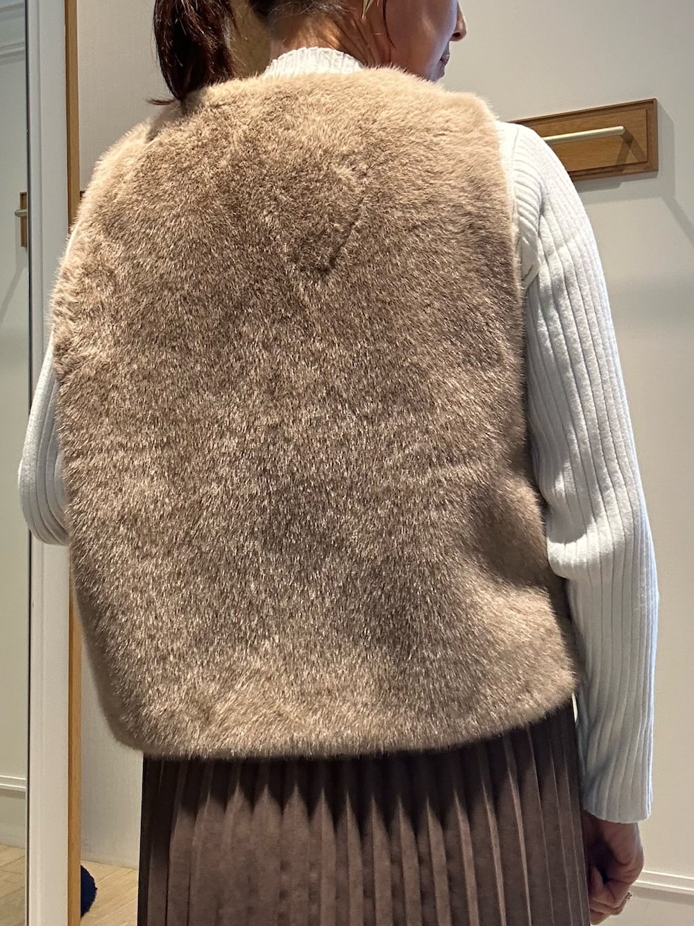 ホワイト系のニット/セーター、ブラウン系のスカート、ブラウン系のブルゾンを着用したレディースの秋コーディネートの7枚目の写真