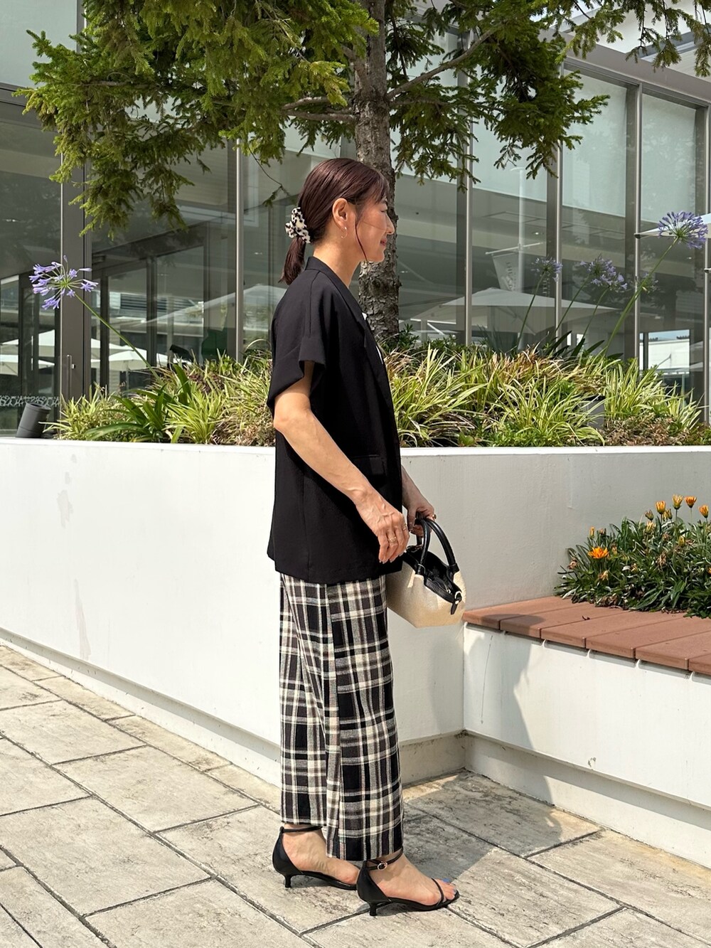 ブラック系のテーラードジャケット、ホワイト系のTシャツ/カットソー、ブラック系のバックパック/リュックを着用したレディースの夏コーディネートの5枚目の写真