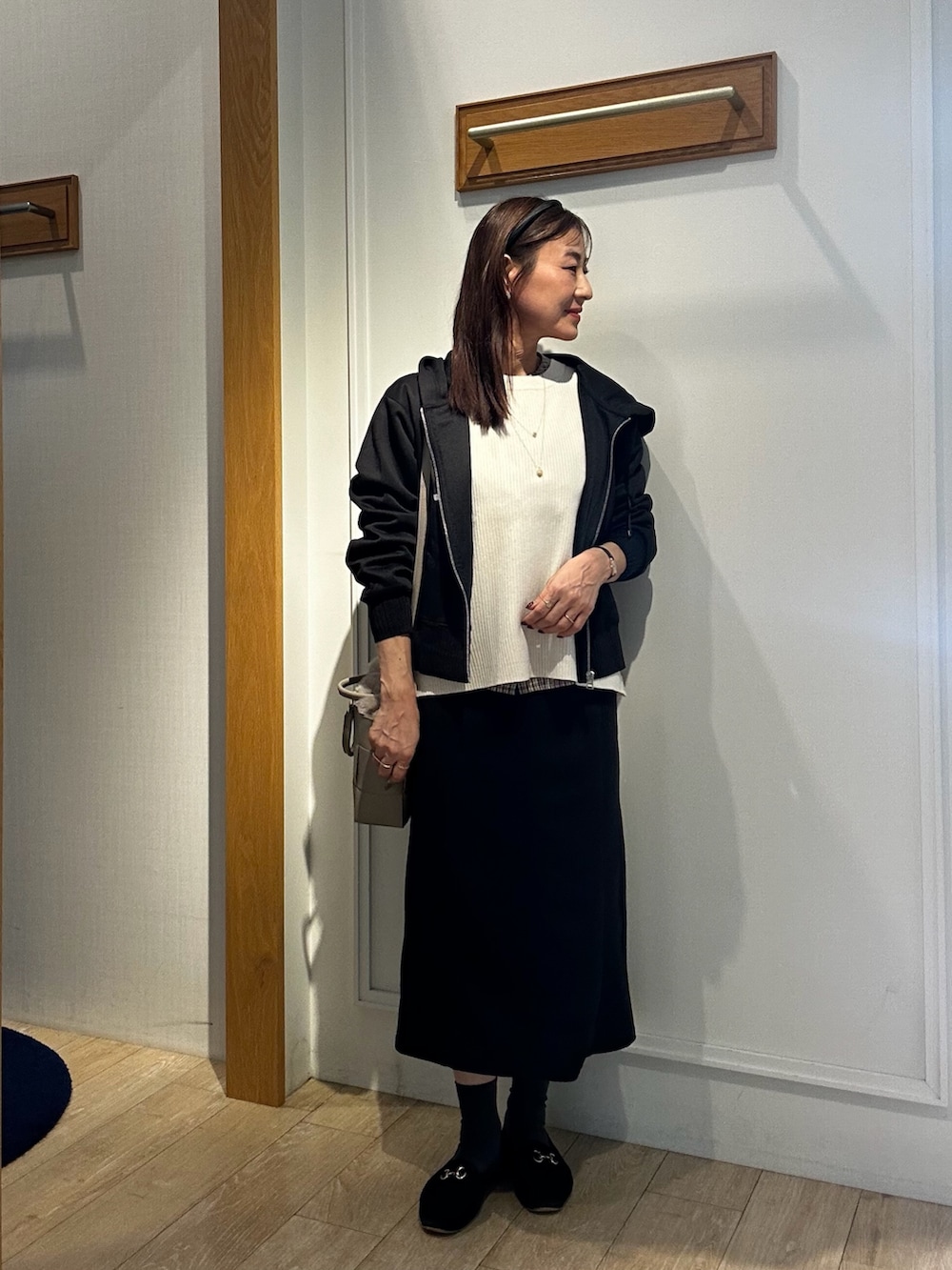 ブラック系のパーカー、ホワイト系のニット/セーター、ブラウン系のシャツ/ブラウスを着用したレディースの秋コーディネートの4枚目の写真