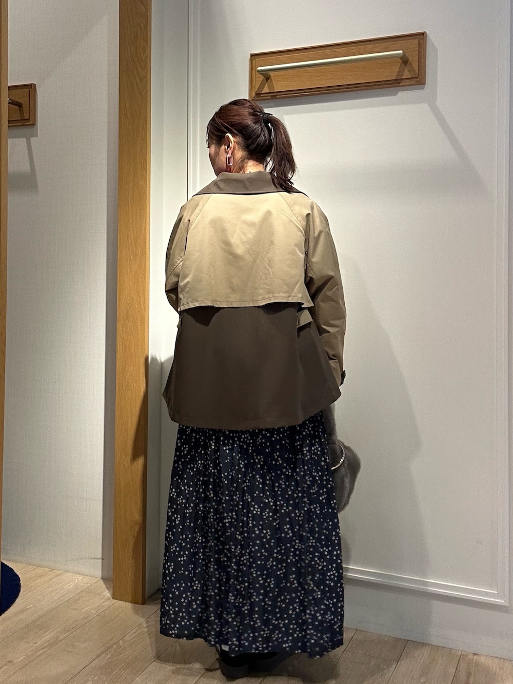 イエロー系のトレンチコート、ピンク系のニット/セーターを着用したレディースの秋コーディネートの5枚目の写真