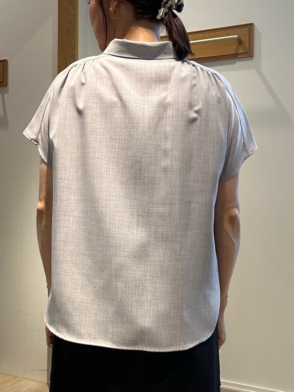 グレー系のシャツ/ブラウス、ブラック系のスカート、ブラック系のバックパック/リュックを着用したレディースの夏コーディネートの8枚目の写真