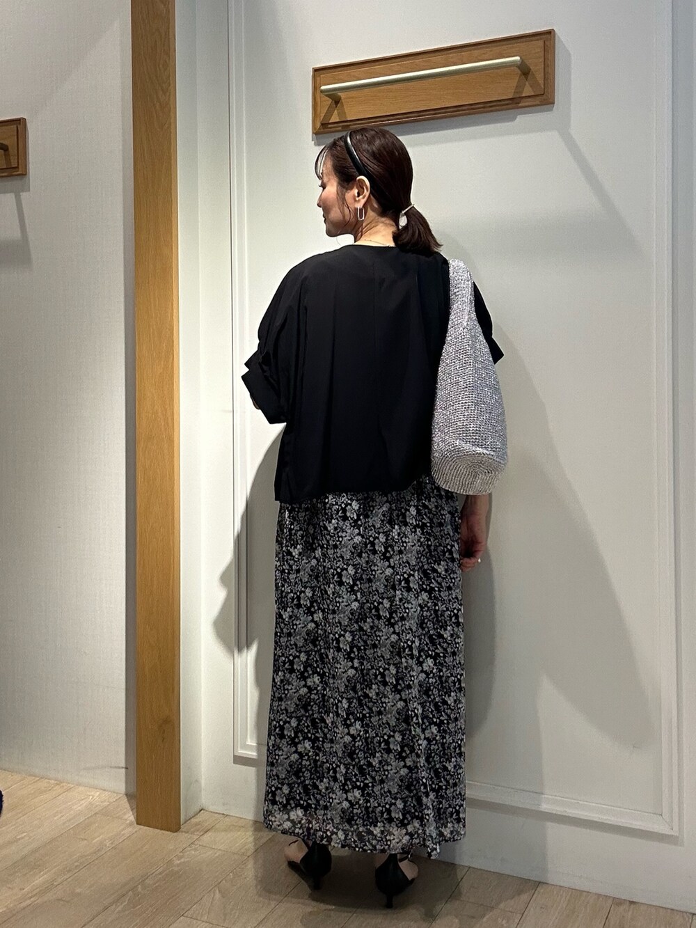 ブラック系のワンピース、ブラック系のノーカラージャケット、ブラック系のサンダルを着用したレディースの夏コーディネートの3枚目の写真