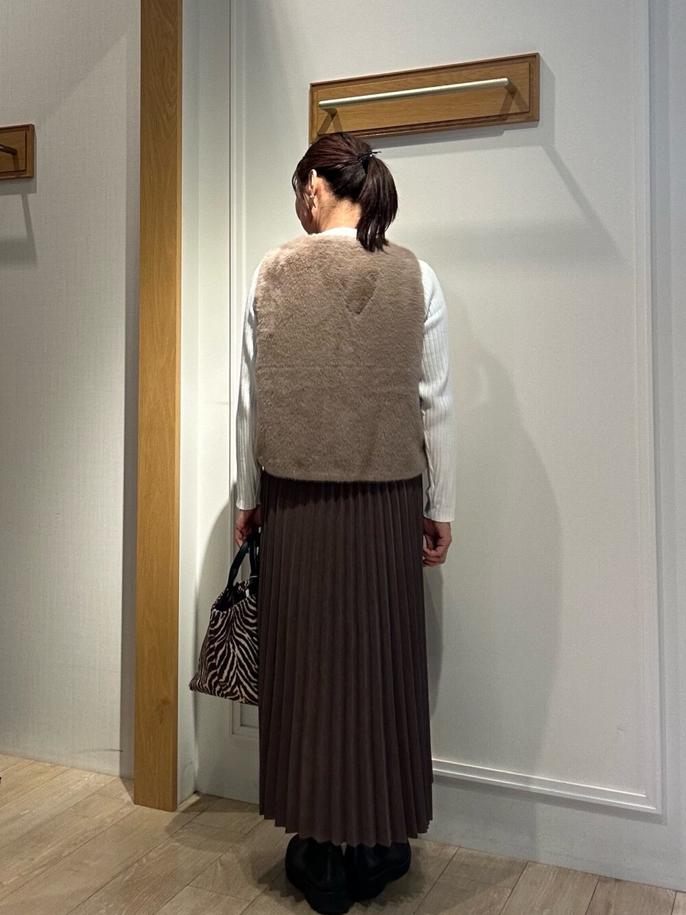 ホワイト系のニット/セーター、ブラウン系のスカート、ブラウン系のブルゾンを着用したレディースの秋コーディネートの3枚目の写真