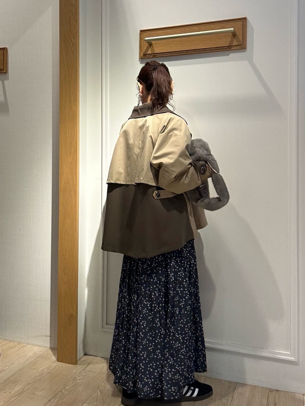 イエロー系のトレンチコート、ピンク系のニット/セーターを着用したレディースの秋コーディネートの3枚目の写真