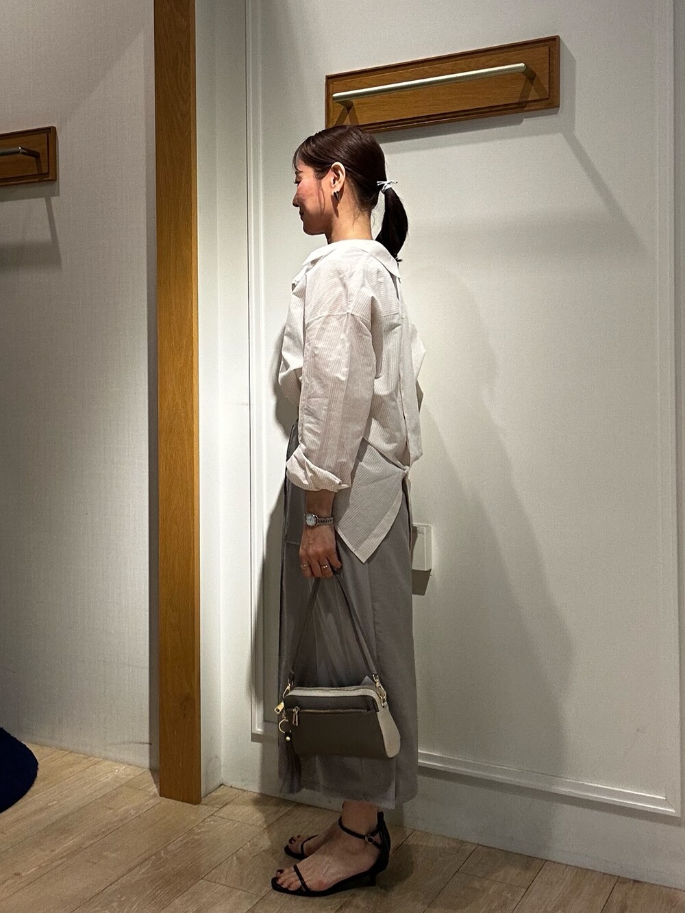 ベージュ系のシャツ/ブラウス、グレー系のスカート、グレー系のショルダーバッグを着用したレディースの春コーディネートの2枚目の写真
