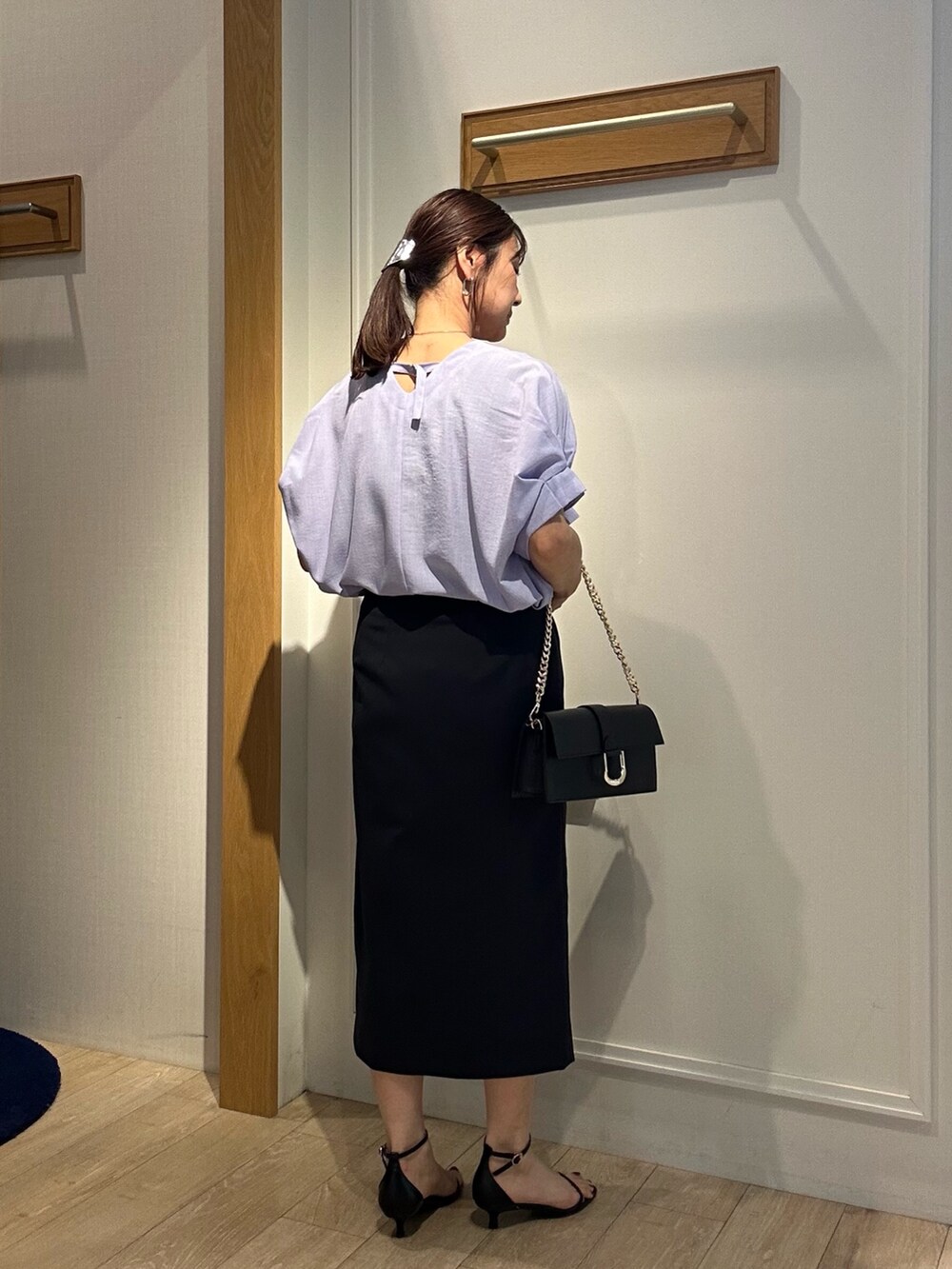 パープル系のシャツ/ブラウス、ブルー系のスカート、ブラック系のショルダーバッグを着用したレディースの春コーディネートの3枚目の写真