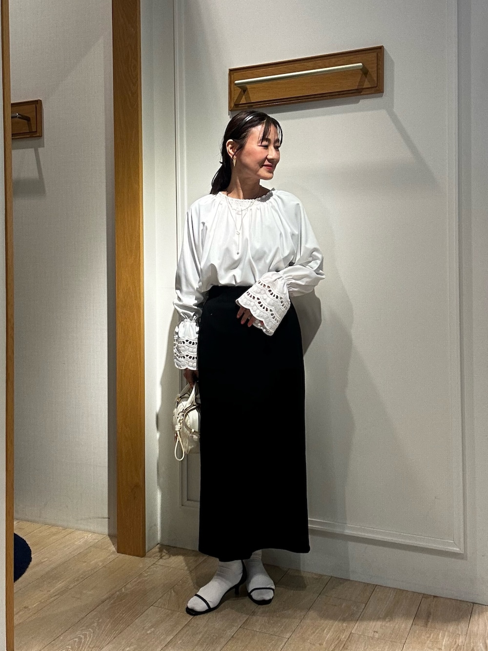 ホワイト系のショルダーバッグ、ホワイト系のシャツ/ブラウス、ベージュ系のブルゾンを着用したレディースの冬コーディネートの7枚目の写真