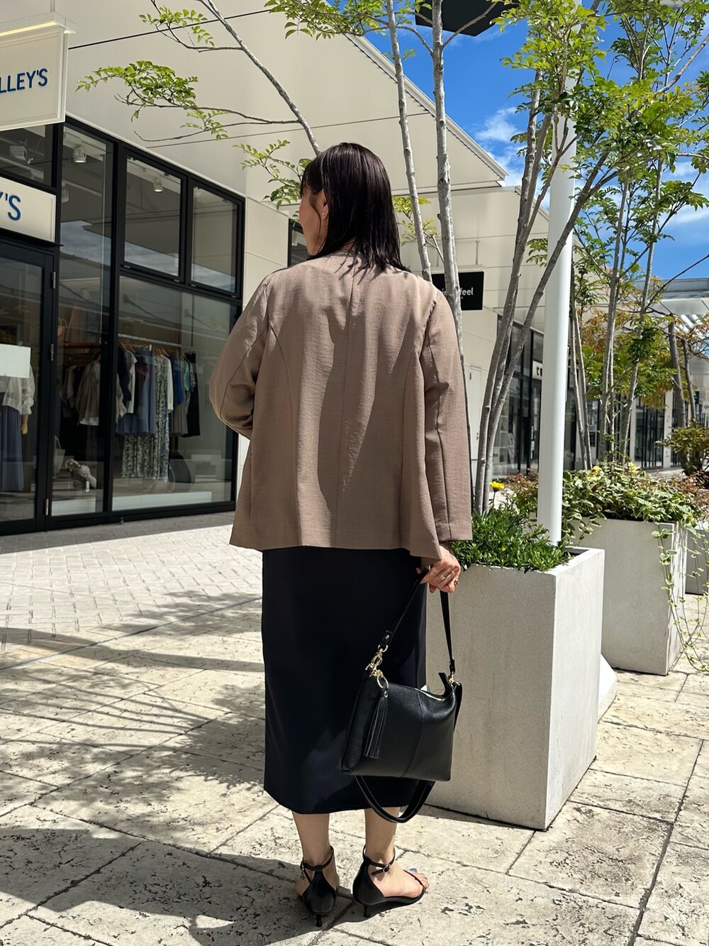 ブルー系のスカート、イエロー系のノーカラージャケット、ベージュ系のシャツ/ブラウスを着用したレディースの夏コーディネートの9枚目の写真