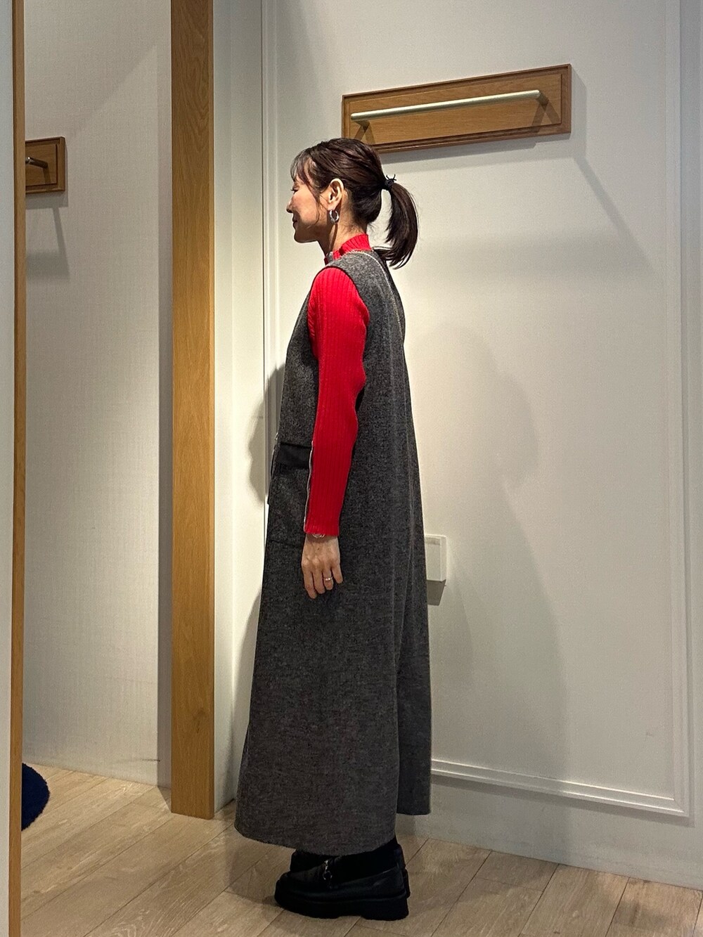 グレー系のワンピース、レッド系のニット/セーターを着用したレディースの秋コーディネートの2枚目の写真