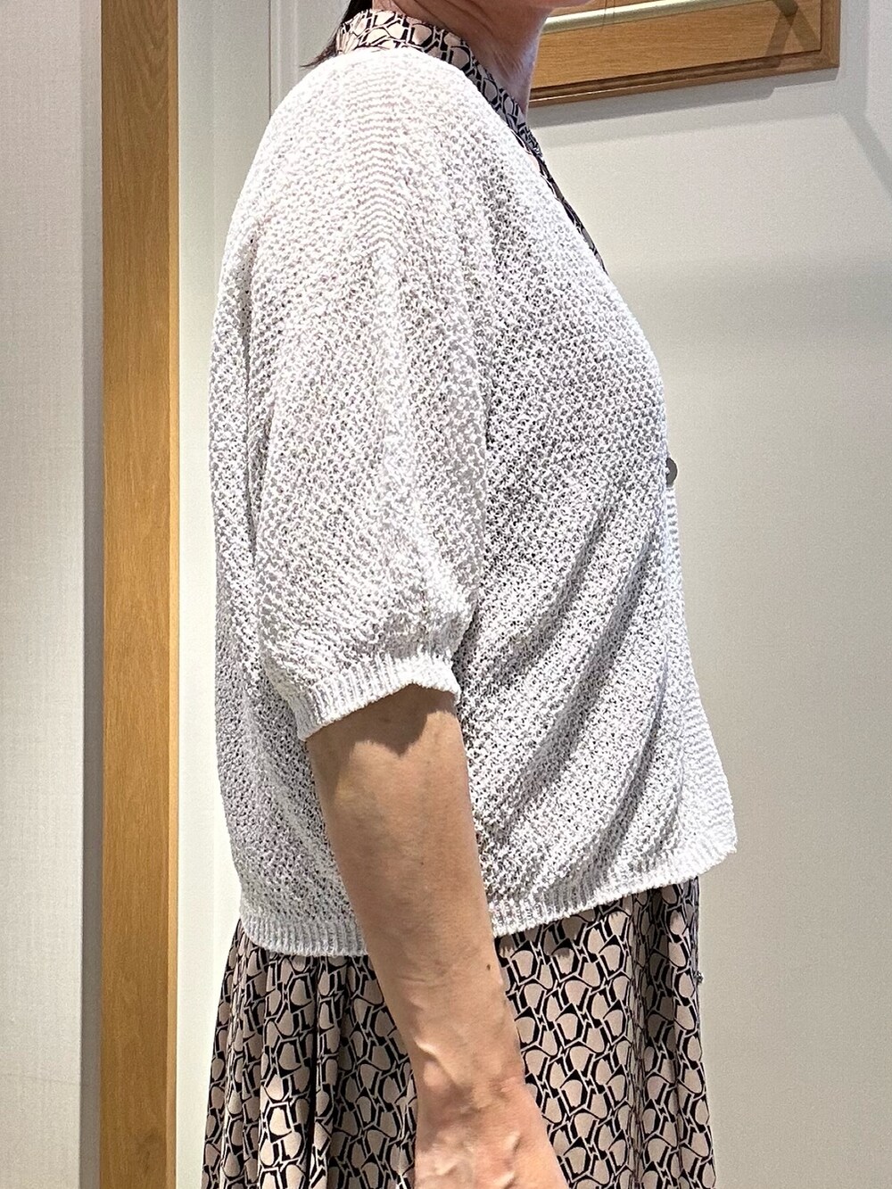 ベージュ系のワンピース、ホワイト系のカーディガン/ボレロ、ゴールド系のショルダーバッグを着用したレディースの春コーディネートの8枚目の写真