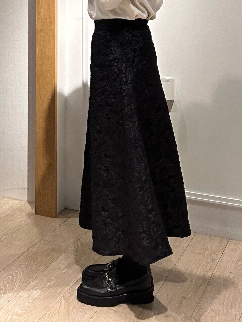 グリーン系のニット/セーター、グレー系のスカート、イエロー系のブルゾンを着用したレディースの秋コーディネートの9枚目の写真