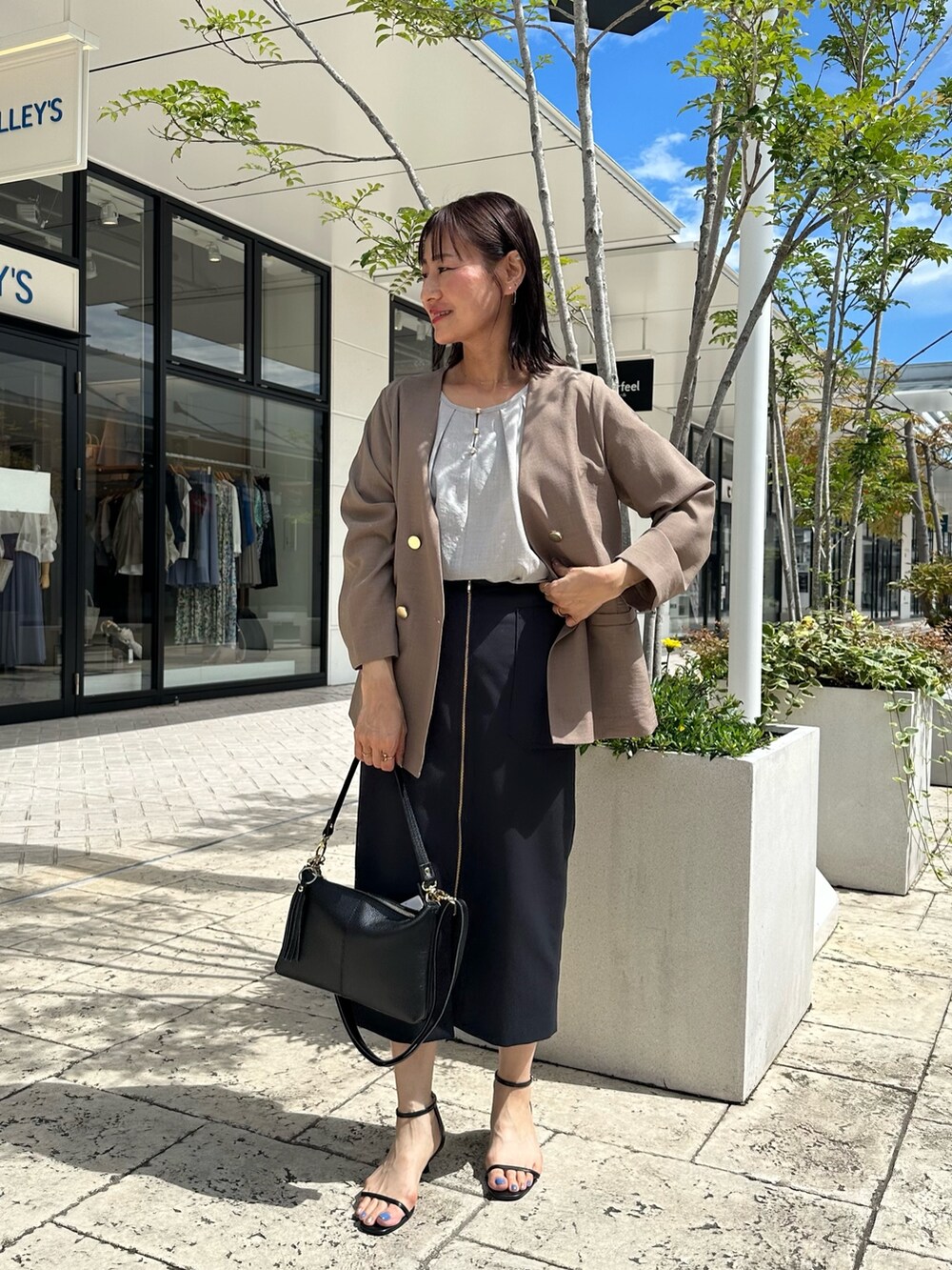 ブルー系のスカート、イエロー系のノーカラージャケット、ベージュ系のシャツ/ブラウスを着用したレディースの夏コーディネートの7枚目の写真
