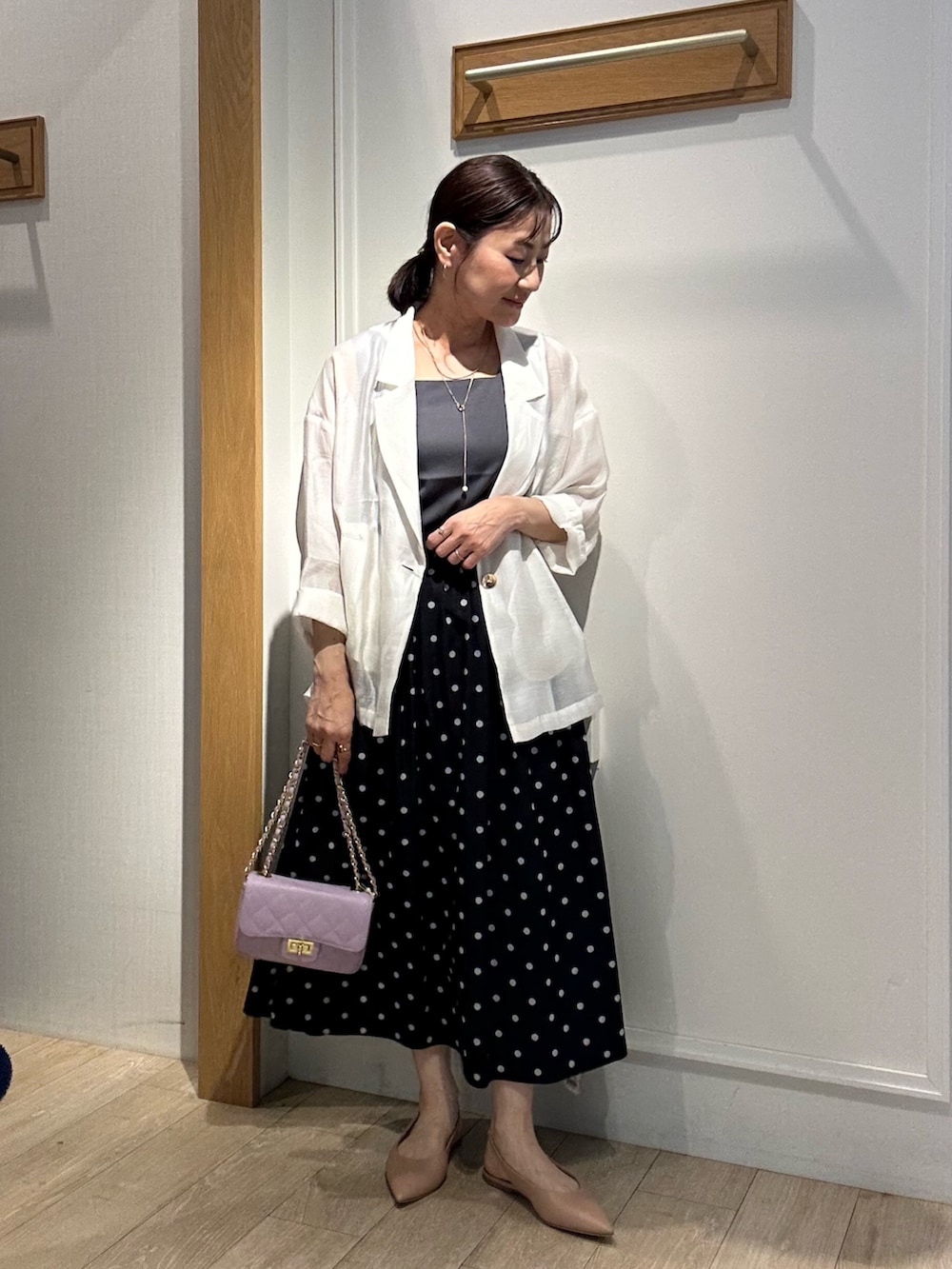 グレー系のTシャツ/カットソー、ホワイト系のテーラードジャケット、ブラック系のスカートを着用したレディースの春コーディネートの10枚目の写真