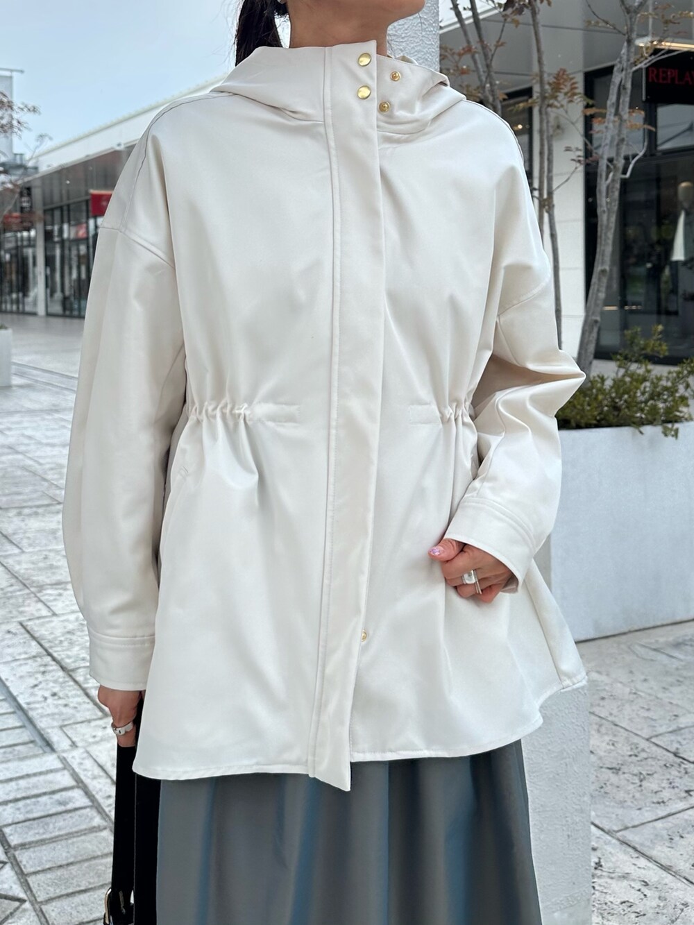 ホワイト系のブルゾン、イエロー系のシャツ/ブラウス、グリーン系のスカートを着用したレディースの冬コーディネートの10枚目の写真