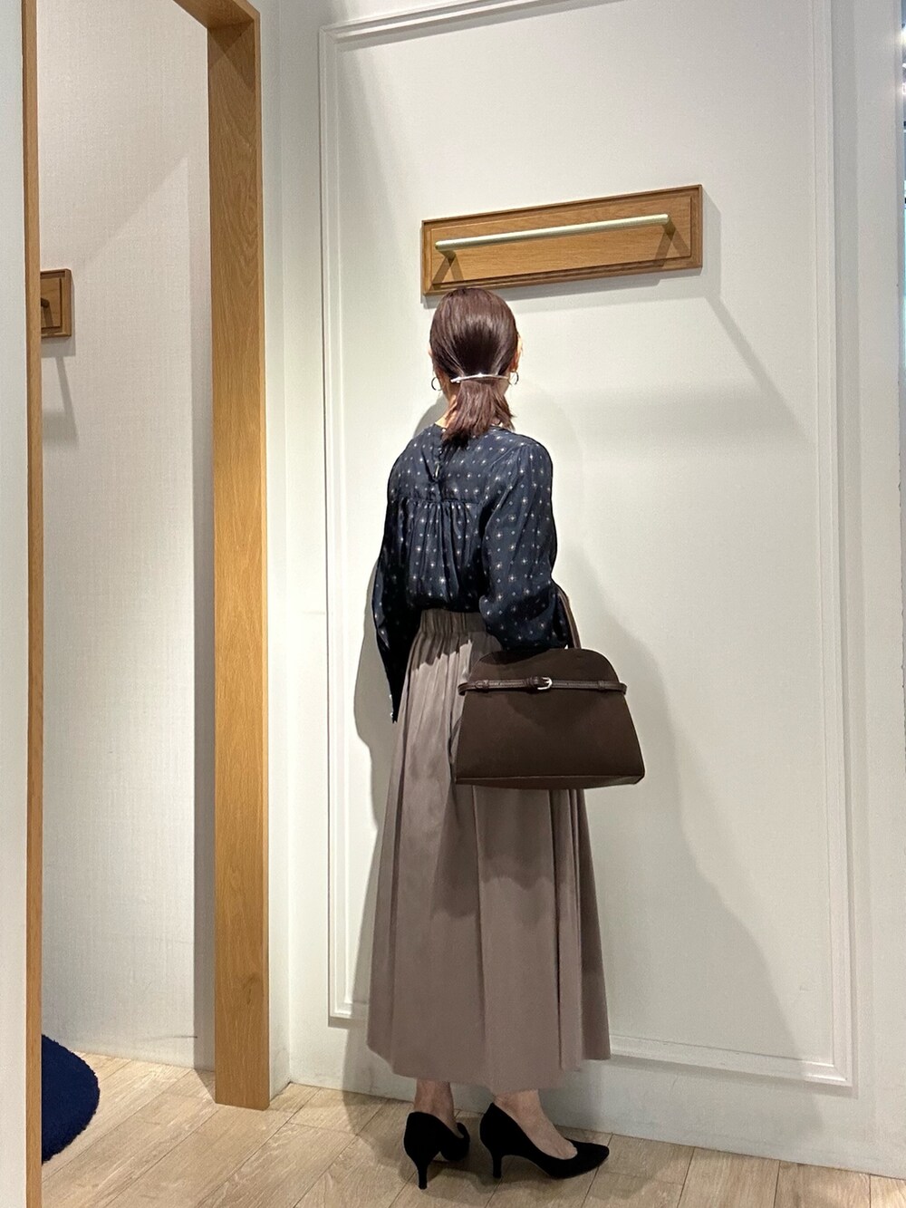 グレー系のテーラードジャケット、ブラウン系のスカート、ブルー系のシャツ/ブラウスを着用したレディースの秋コーディネートの10枚目の写真