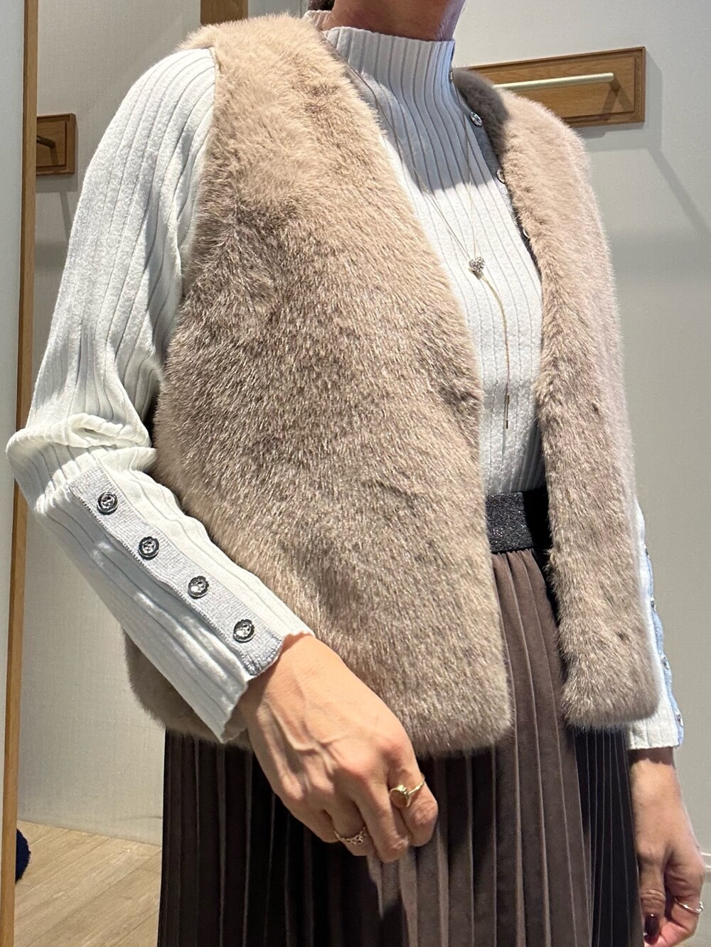 ホワイト系のニット/セーター、ブラウン系のスカート、ブラウン系のブルゾンを着用したレディースの秋コーディネートの4枚目の写真