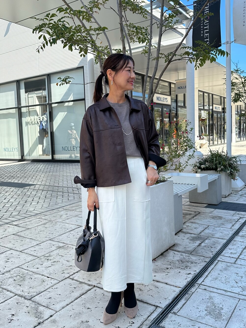 ブラウン系のニット/セーター、グレー系のスカート、ブラウン系のブルゾンを着用したレディースの秋コーディネートの10枚目の写真