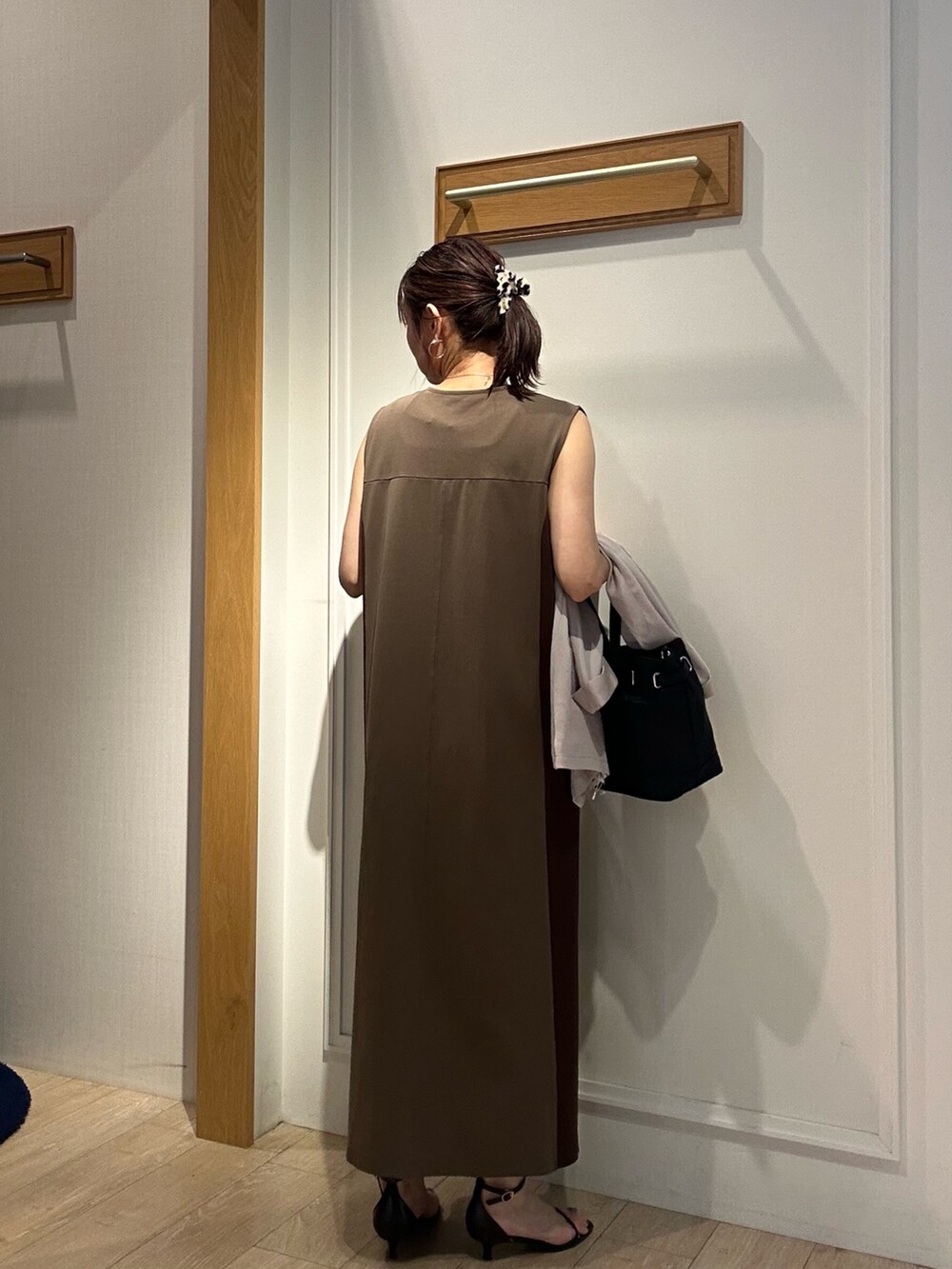 ブラウン系のワンピース、ブラック系のサンダル、ベージュ系のテーラードジャケットを着用したレディースの夏コーディネートの3枚目の写真