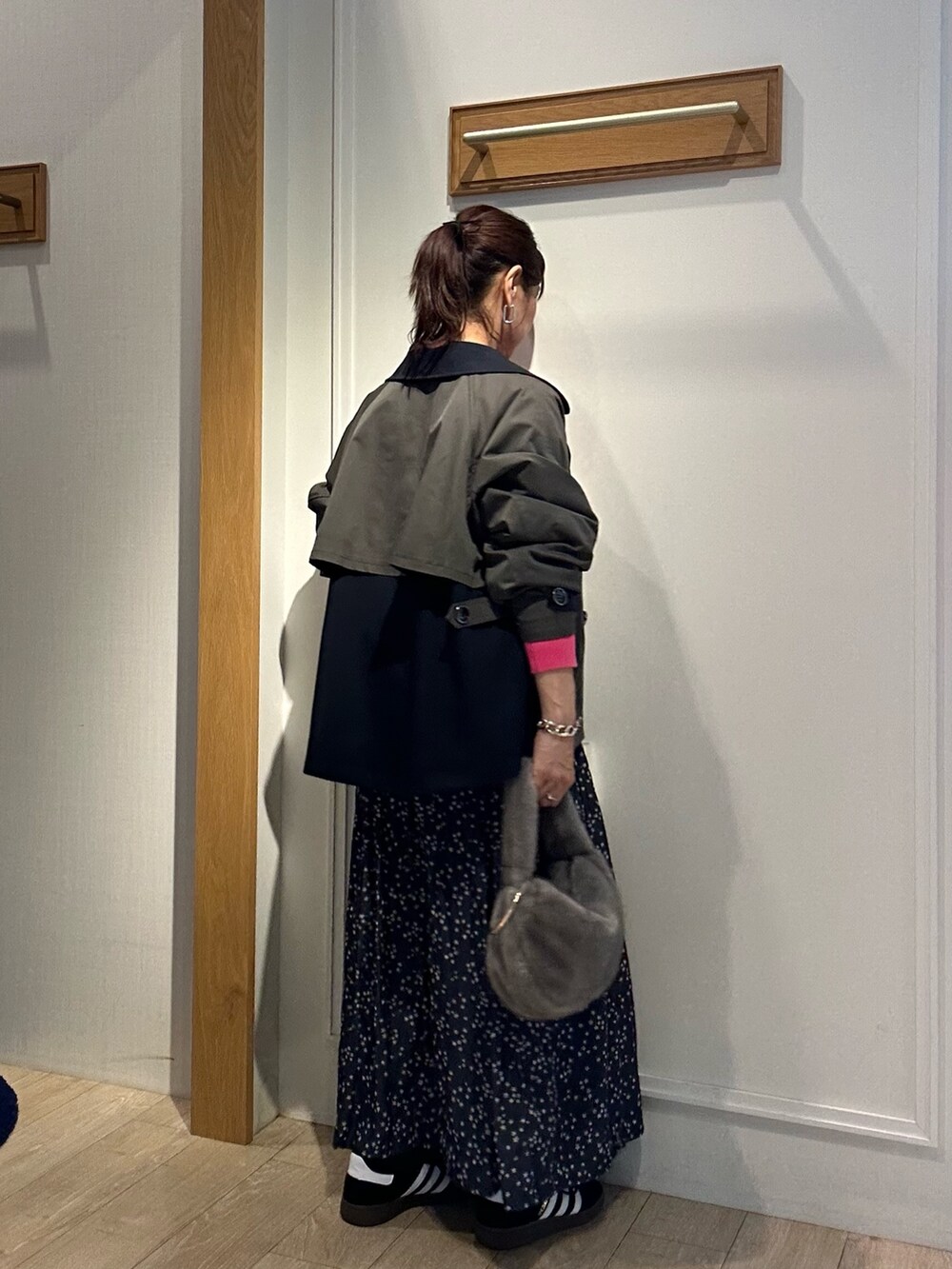 グレー系のトレンチコート、ピンク系のニット/セーターを着用したレディースの秋コーディネートの6枚目の写真