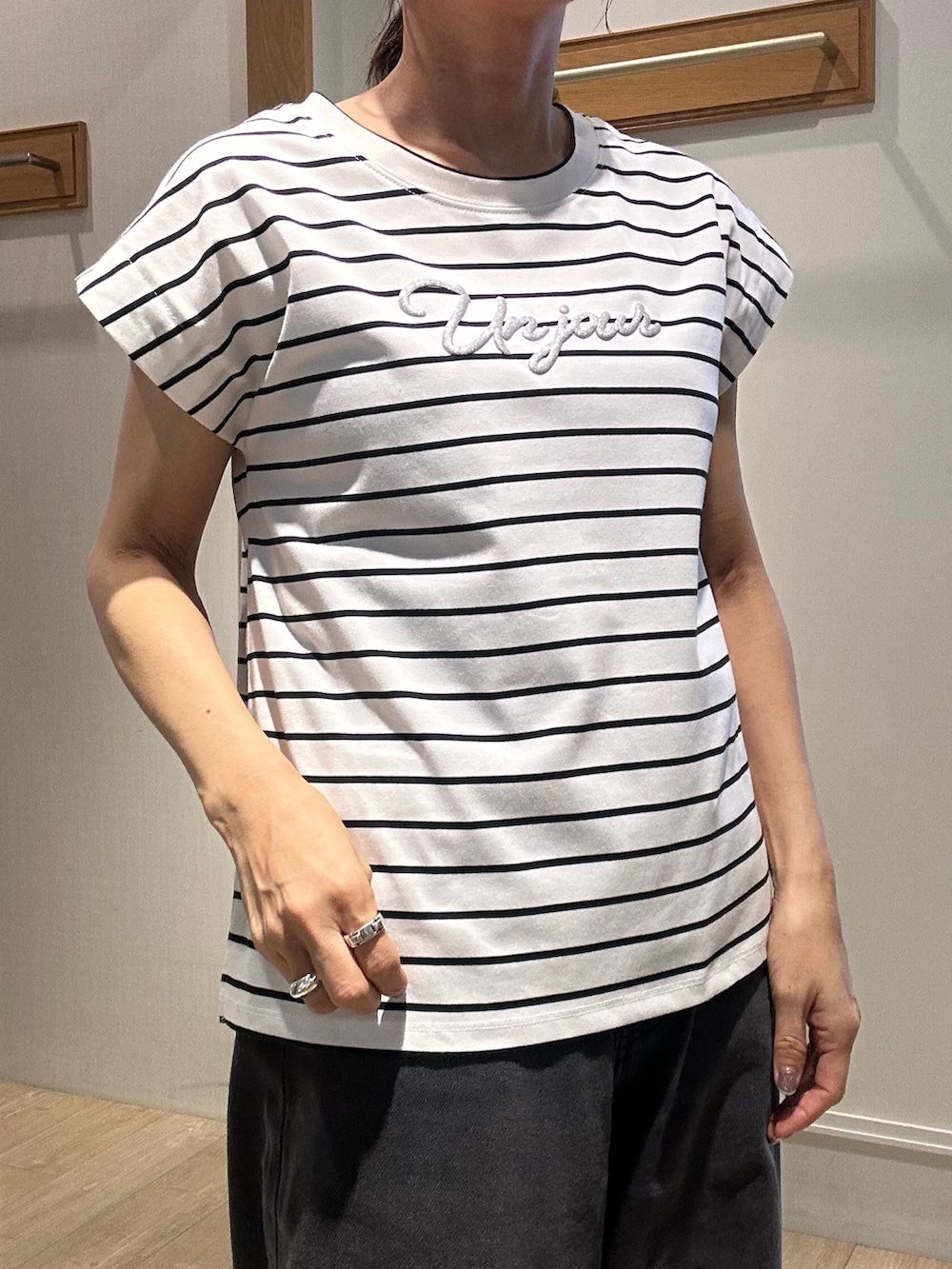 ホワイト系のTシャツ/カットソー、ブラック系のサンダル、ホワイト系のボストンバッグを着用したレディースの夏コーディネートの7枚目の写真