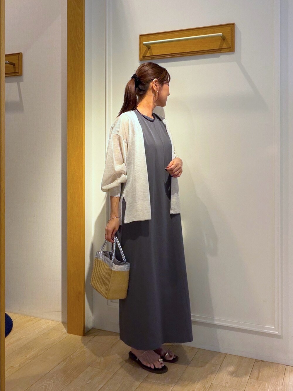 ベージュ系のカーディガン/ボレロ、グレー系のワンピース、ブラック系のネックレスを着用したレディースの夏コーディネートの4枚目の写真