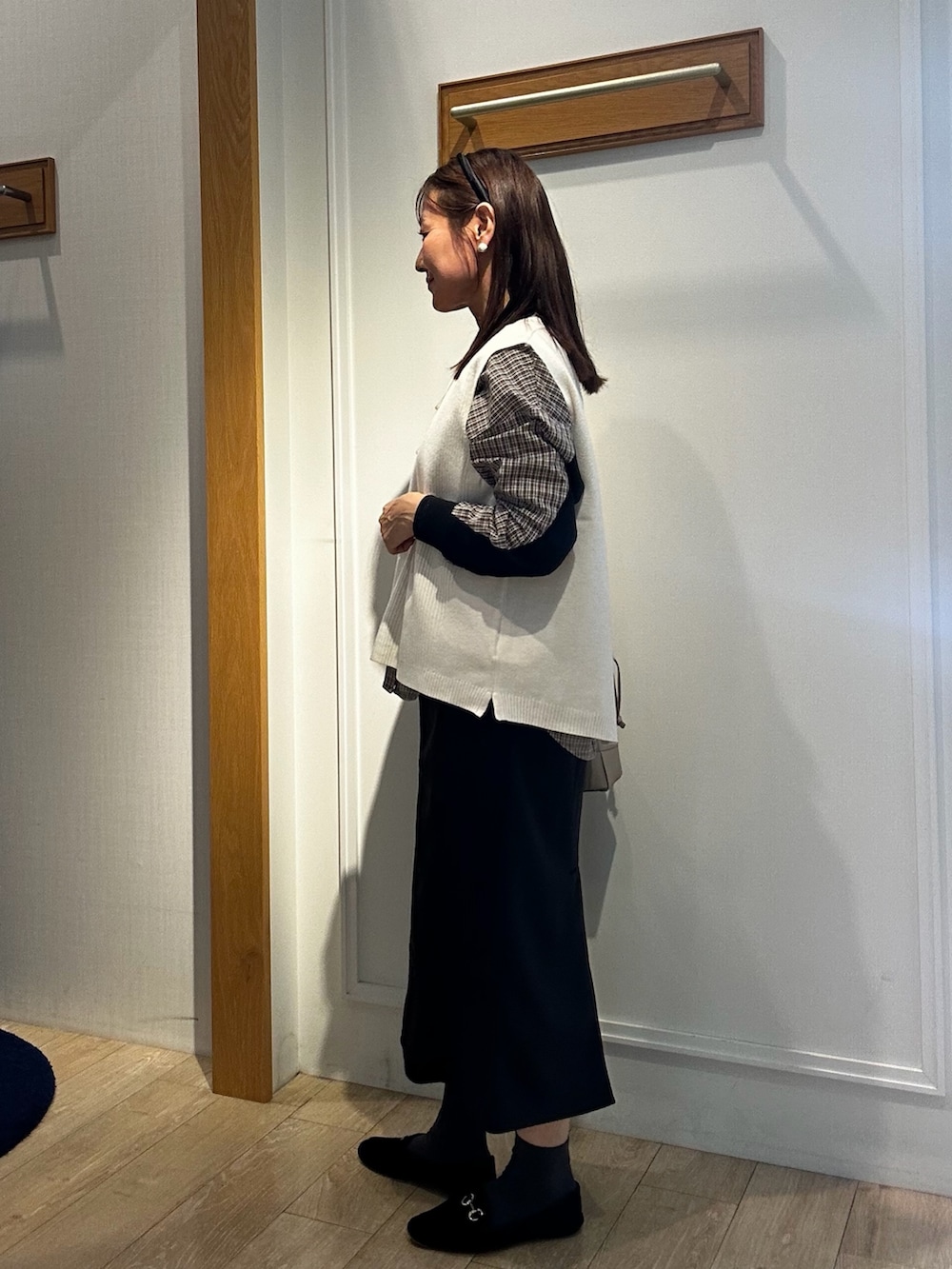 ブラック系のパーカー、ホワイト系のニット/セーター、ブラウン系のシャツ/ブラウスを着用したレディースの秋コーディネートの6枚目の写真