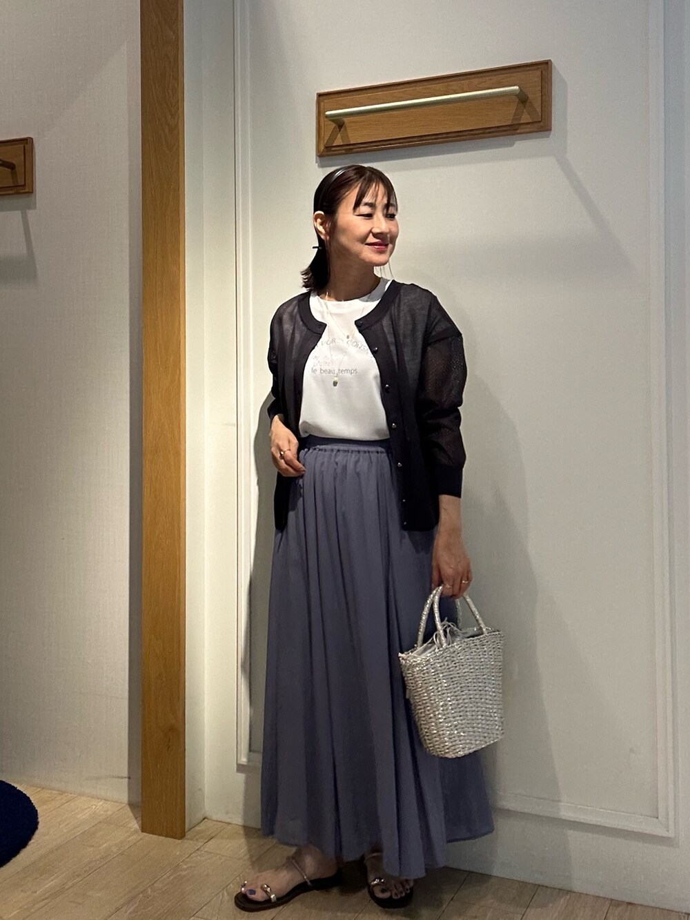 パープル系のスカート、ホワイト系のシャツ/ブラウス、グレー系のカーディガン/ボレロを着用したレディースの夏コーディネートの10枚目の写真