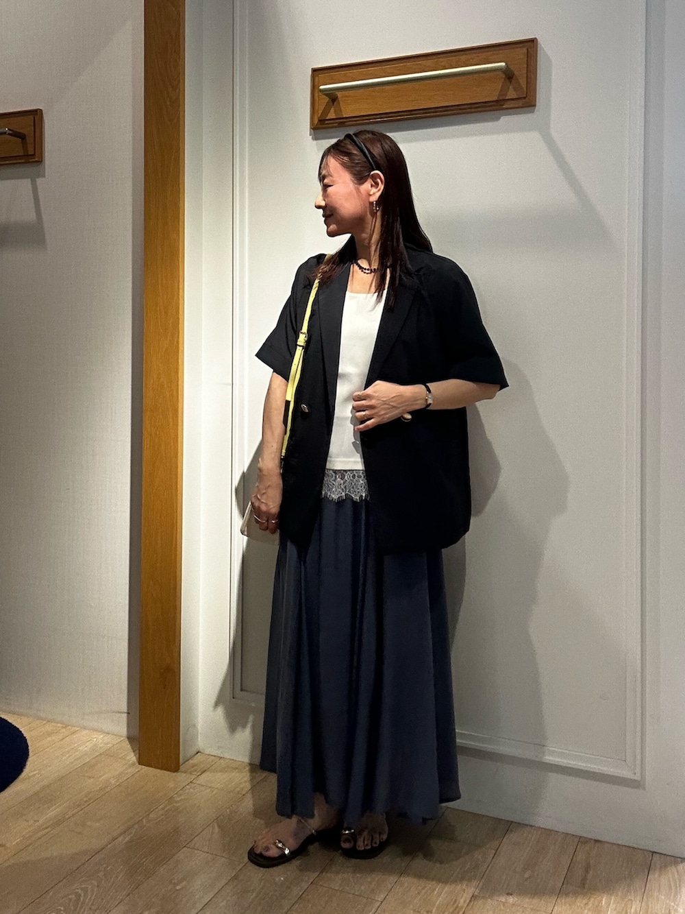 グレー系のテーラードジャケット、ホワイト系のTシャツ/カットソー、ブルー系のスカートを着用したレディースの夏コーディネートの2枚目の写真