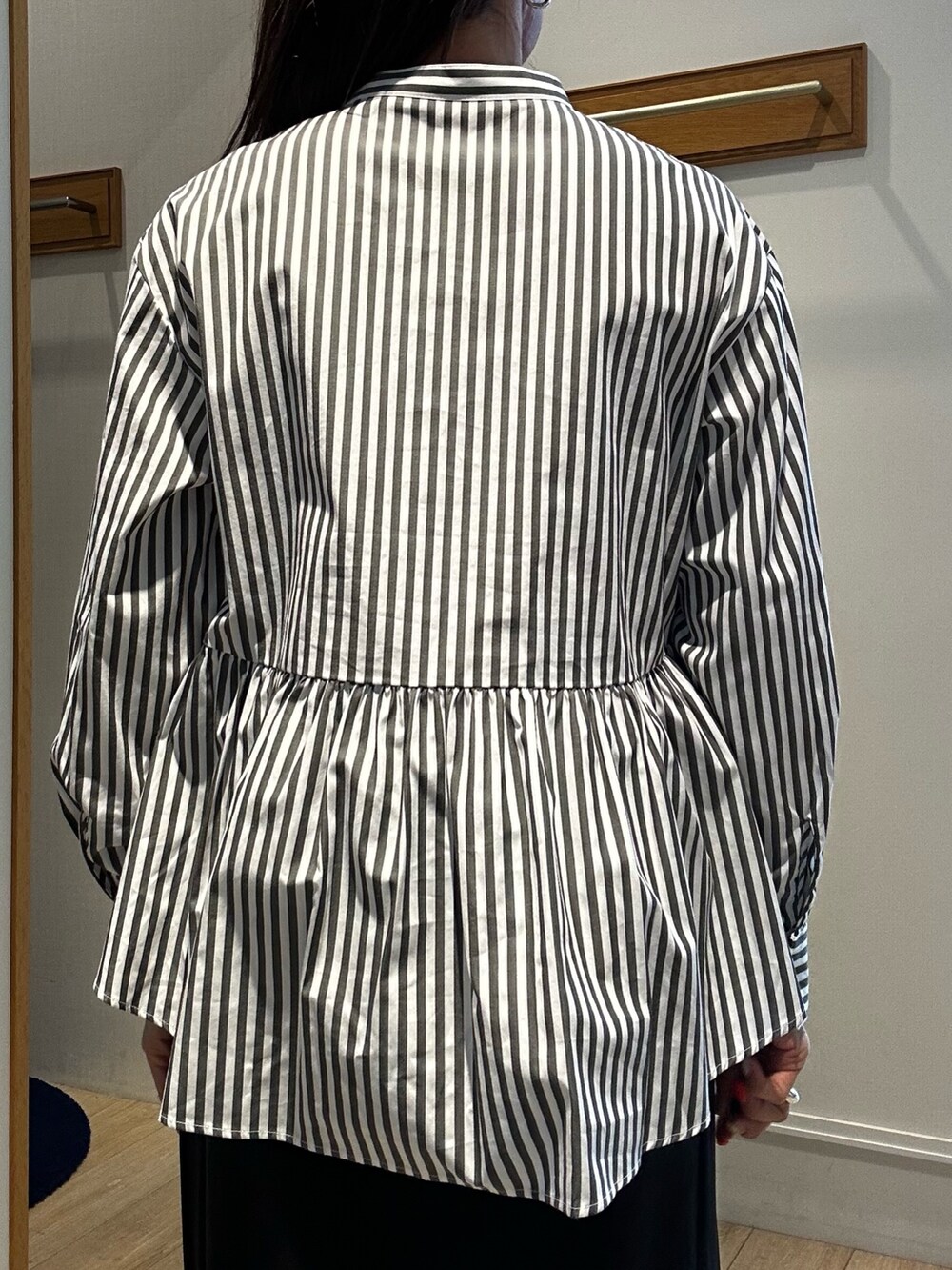 ブラック系のスカート、グレー系のシャツ/ブラウスを着用したレディースの春コーディネートの6枚目の写真