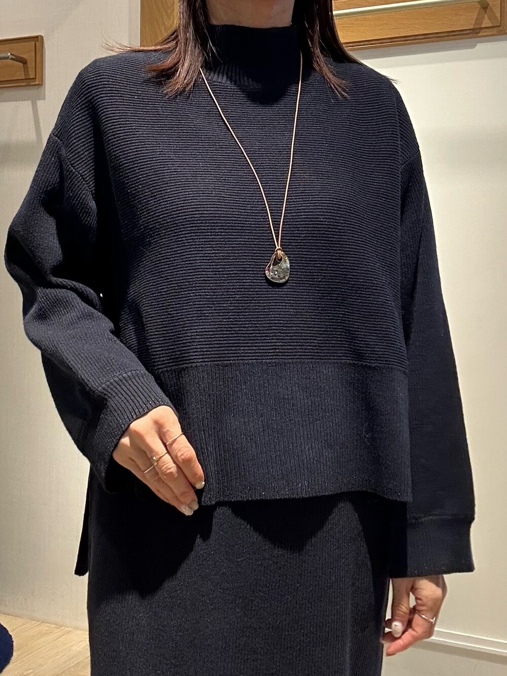 ホワイト系のトートバッグ、ブラウン系のローファー、ブルー系のニット/セーターを着用したレディースの冬コーディネートの9枚目の写真