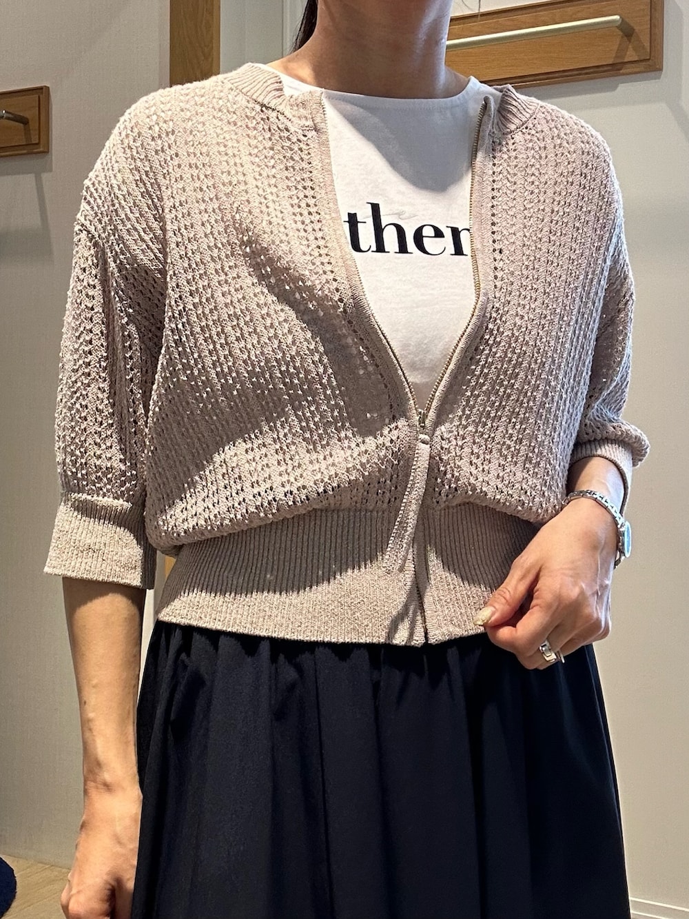 ベージュ系のニット/セーター、ホワイト系のTシャツ/カットソー、ブルー系のスカートを着用したレディースの春コーディネートの8枚目の写真