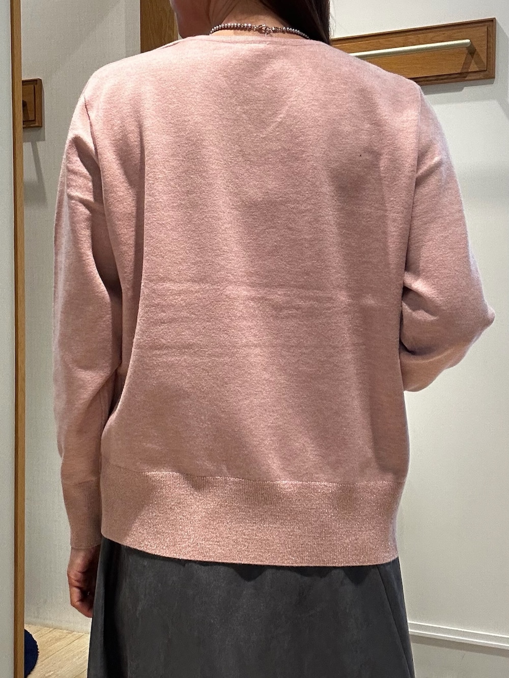 ピンク系のニット/セーター、グレー系のスカート、ブルー系のショルダーバッグを着用したレディースの秋コーディネートの6枚目の写真