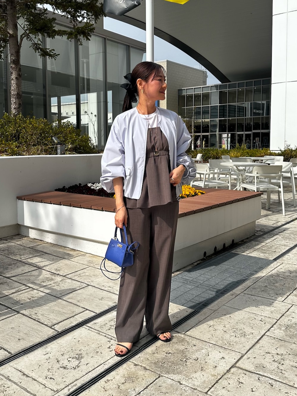 グリーン系のシャツ/ブラウス、ブルー系のブルゾン、ブルー系のショルダーバッグを着用したレディースの春コーディネートの7枚目の写真